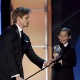 O apresentador Bradley Jame segura o microfone Jacob Tremblay, melhor atuação jovem por "O Quarto de Jack" - REUTERS/Mario Anzuoni
