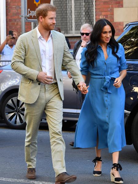 O príncipe Harry e Meghan Markle, na África do Sul. O vestido azul foi usado por ela quando estava grávida, no ano passado, em viagem à Oceania - Mark Large/Reuters