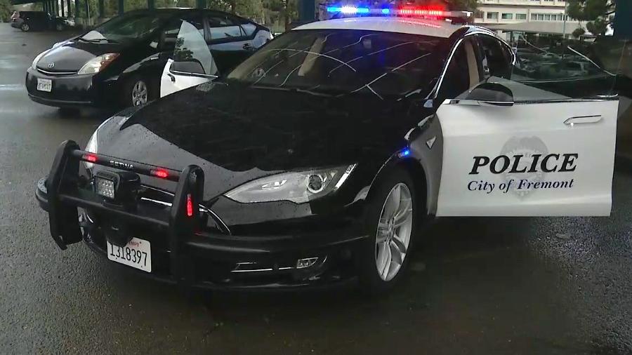 Tesla frente a frente com um carro da polícia. Uma corrida