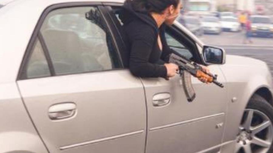 Mulher posa com AK47 em Cadillac - Reprodução