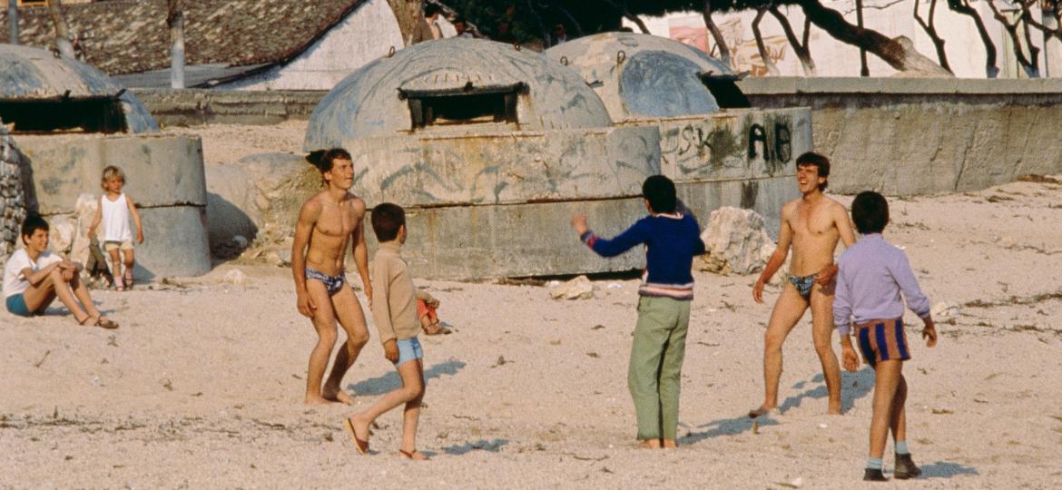 Em foto de 1988, albaneses jogam futebol na praia onde vemos bunkers enterrados na areia - John van Hasselt - Corbis/Sygma via Getty Images