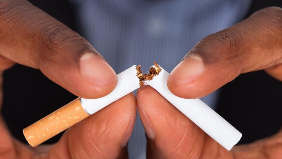 Mãos quebrando um cigarro ao meio, tabagismo, cessação, parar de fumar, tabaco, fumo