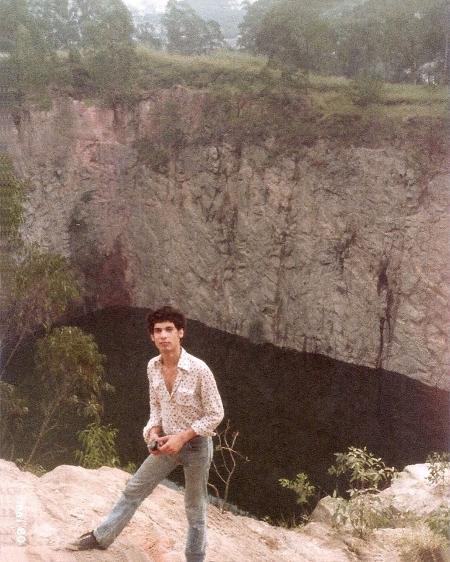 Homem posa em frente à cratera da antiga pedreira do Jardim Educandário