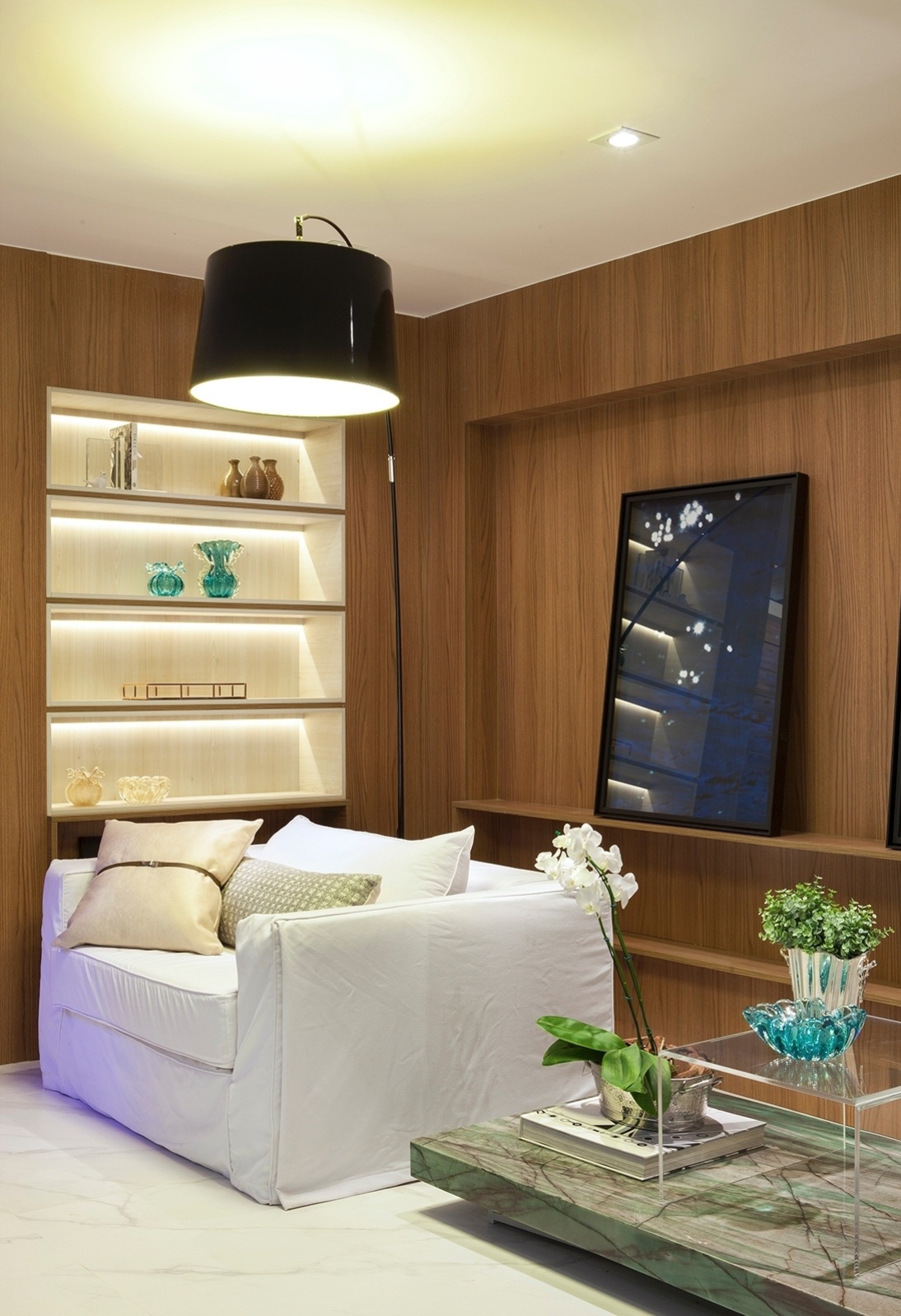 Nas paredes da sala - Uma maneira de proporcionar aconchego ao ambiente é utilizar a madeira nos acabamentos como fez Tamara Raizer, na Casa de Vidro. No projeto, as superfícies trazem nichos embutidos e prateleiras iluminadas que abrigam objetos | A Casa Cor Espírito Santo (www.casacor.com.br) fica em cartaz até 10 de novembro de 2015 - Felipe Araújo/ Divulgação