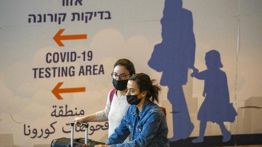 Viajantes desembarcam no aeroporto internacional de Ben Gurion, perto de Tel Aviv, neste domingo (28), poucas horas antes de entrar em vigor as novas restrições para conter a propagação da variante ômicron" - Reprodução/RFI