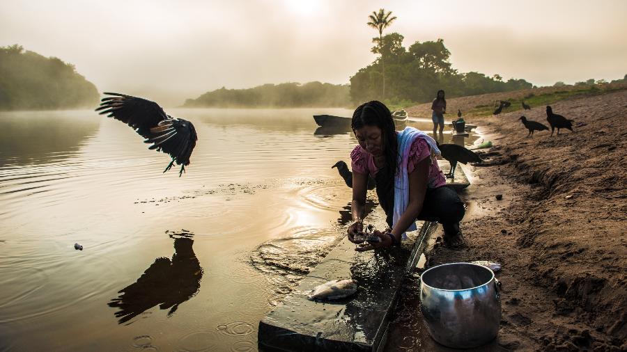 Uma mulher do povo Munduruku limpa peixes que acabou de pescar - Fábio Nascimento