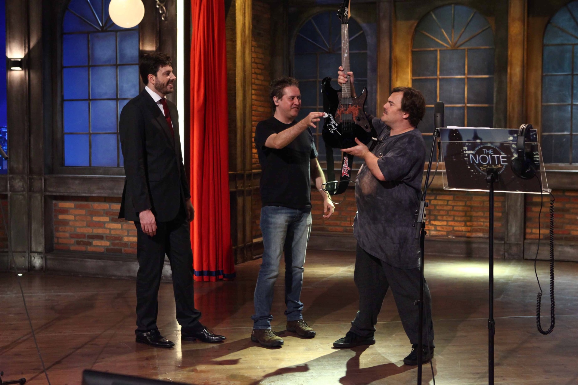 21.out.2015 - Jack Black ganha guitarra autografa por Andreas Kisser, do Sepultura, durante participação no "The Noite" - Leonardo Nones/SBT/Divulgação