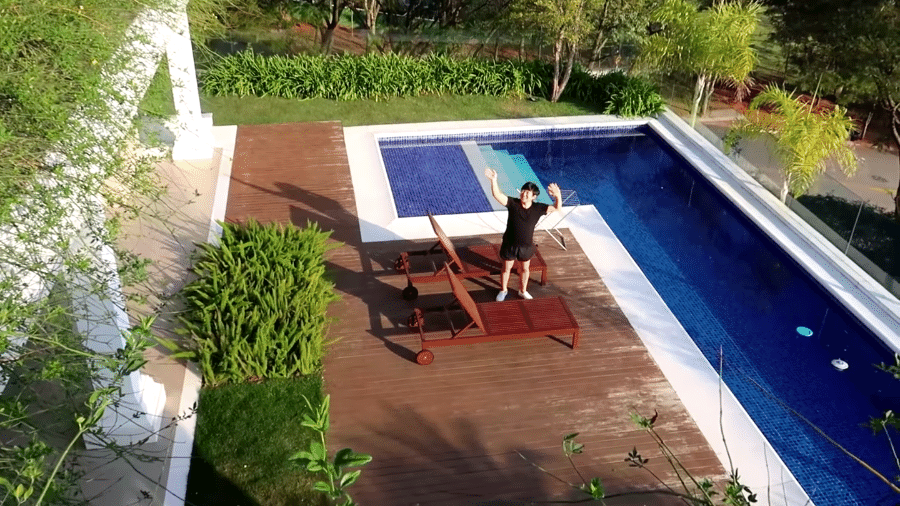 Pyong posa na área da piscina de sua nova casa, em Alphaville - Reprodução/YouTube