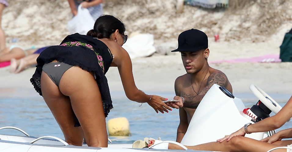 28.jul.2015- A morena que acompanhava o jogador do Barcelona foi traída pelo vento, que levantou sua saia. Neymar entregou o telefone 