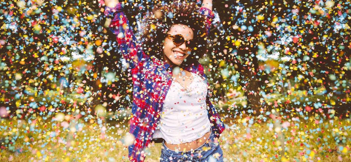 mulher feliz, chuva de confetes - Getty Images
