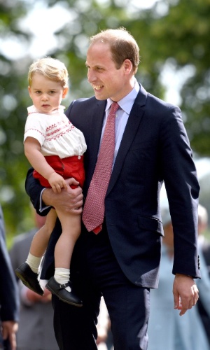 5.jul.2015 - Príncipe George no colo do pai, o príncipe William, duque de Cambridge, na saída do batizado da pequena Charlotte, na igreja Santa Maria Madalena, em Sandringham, na Inglaterra.