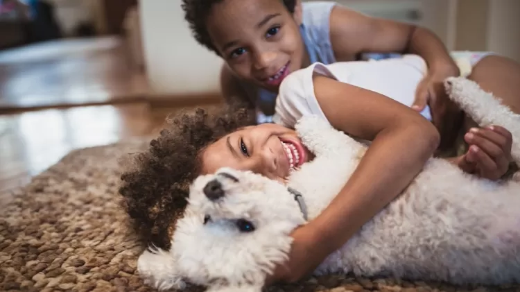 Crianças sorrindo com cachorro - NoSystem images/iStock - NoSystem images/iStock