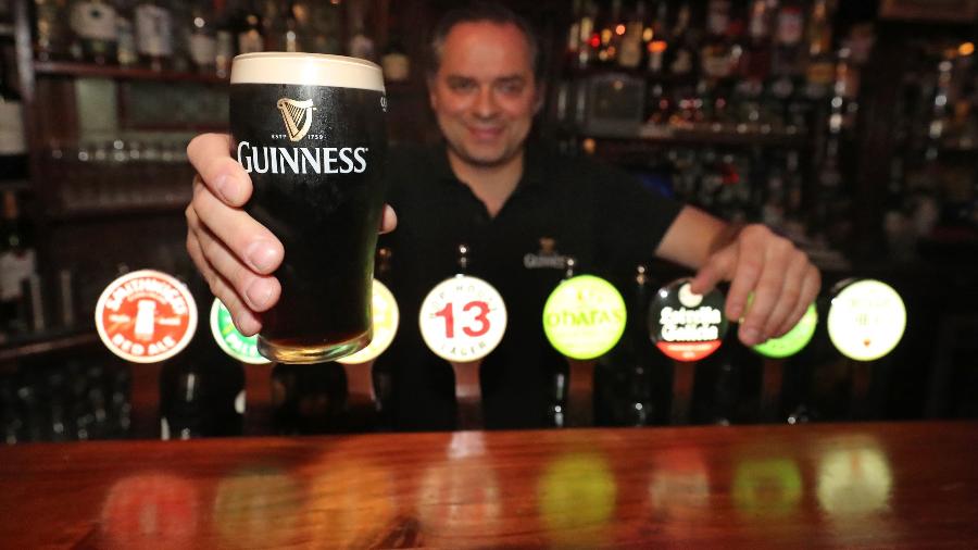 Dono do pub Paddy Cullen, em Dublin (Irlanda), mostra um chope da tradicional Guinness - Getty Images
