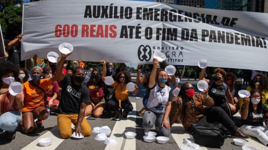Manifestantes levantam marmitas vazias em protesto na av. Paulista, em SP, em março, pedindo a manutenção do auxílio emergencial - Danilo Verpa/Folhapress