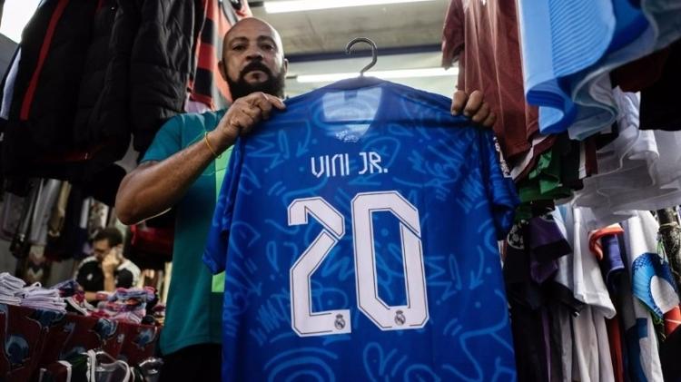 Wanderley Santos, 49 anos, vende camisas esportivas, inclusive do jogador brasileiro Vinicius Junior, em São Gonçalo, sua cidade natal  -  Florian Plaucheur/AFP -  Florian Plaucheur/AFP