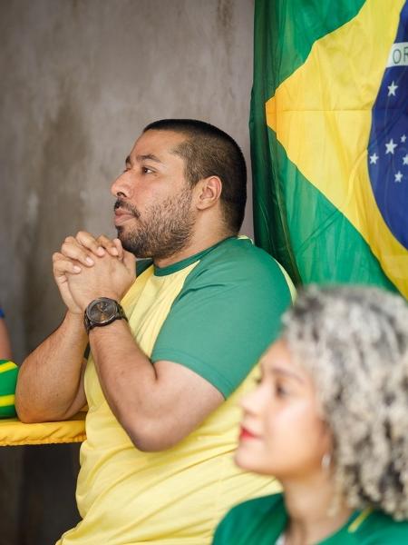 Fã de futebol brasileiro adulto usando smartphone de bandeira assistindo  jogo pelo celular streaming online