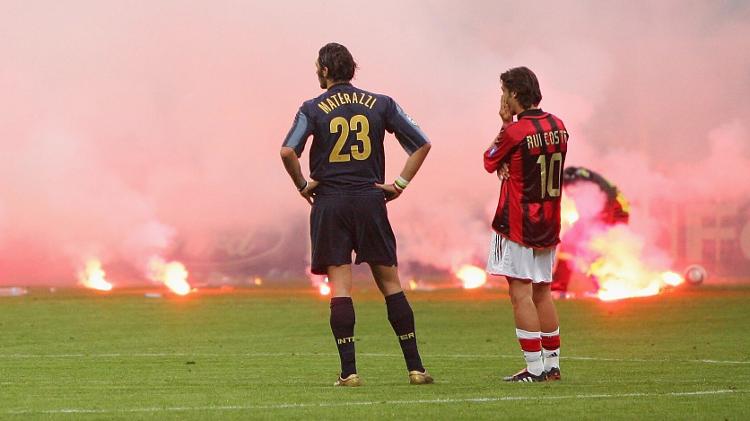 Materazzi e Rui Costa observam caos no Giuseppe Meazza durante Inter e Milan, jogo ocorrido em 2005