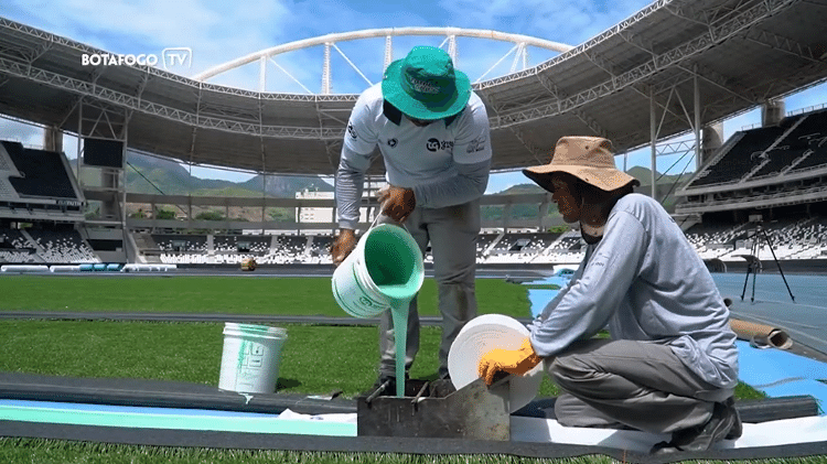 Funcionários trabalham na implementação do gramado sintético do Nilton Santos, estádio do Botafogo - Reprodução / Botafogo TV - Reprodução / Botafogo TV