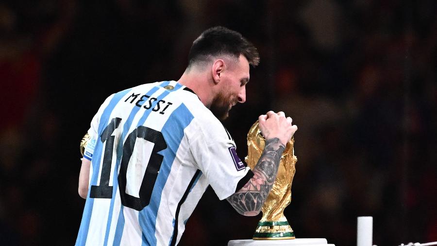 Lionel Messi beija a taça da Copa do Mundo depois da final de 2022 contra a França - ANNE-CHRISTINE POUJOULAT/AFP