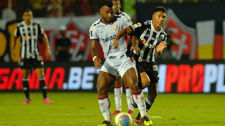 Zaracho e Luan disputam a bola durante Vitória x Atlético-MG, jogo válido pelo Campeonato Brasileiro