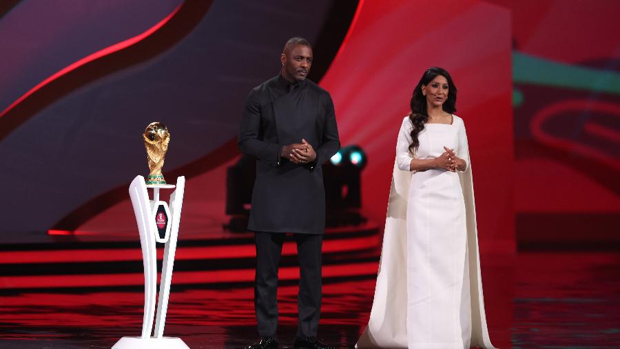 Idris Elba e Reshmin Chowdhury apresentam sorteio dos grupos da Copa do Mundo do Qatar ao lado da taça do torneio - Matthew Ashton - AMA/Getty Images