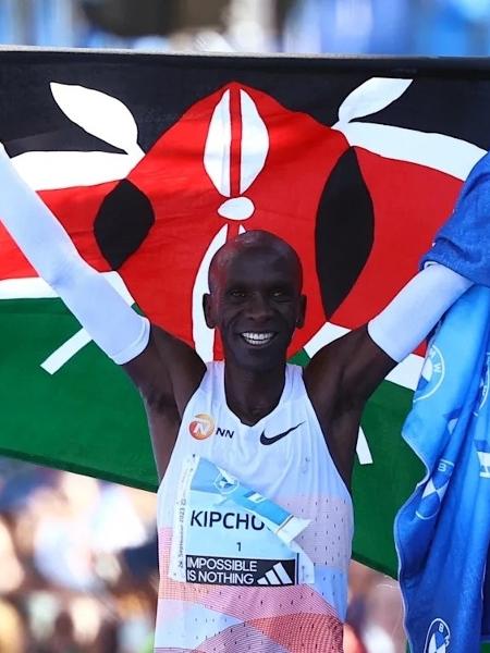 Eliud Kipchoge ergue a bandeira do Quênia na chegada da maratona de Berlim