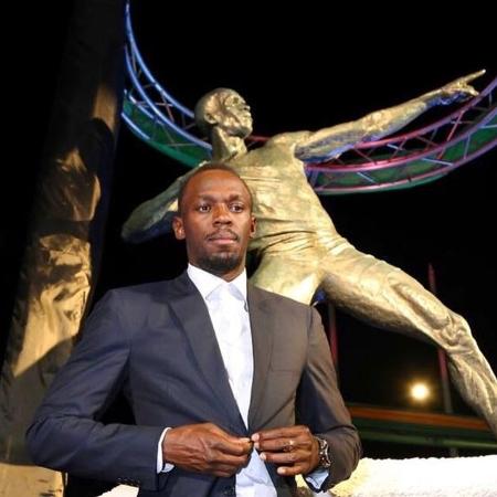 Usain Bolt em frente à estátua inaugurada em sua homenagem - Reprodução/Facebook