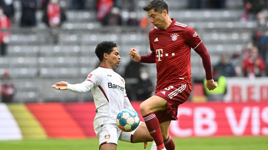 Robert Lewandowski, do Bayern Munique, disputa a bola com Amine Adli, do Bayer Leverkusen, no Alemão - CHRISTOF STACHE / AFP