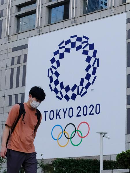 Japoneses caminham em frente a mural da Olimpíada de Tóquio - James Matsumoto/SOPA Images/LightRocket via Getty Images