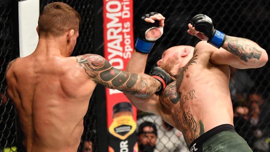Dustin Poirier (de costas) acerta golpe em Conor McGregor (d) e derrota irlandês em luta do UFC 257 - Jeff Bottari/Getty Images