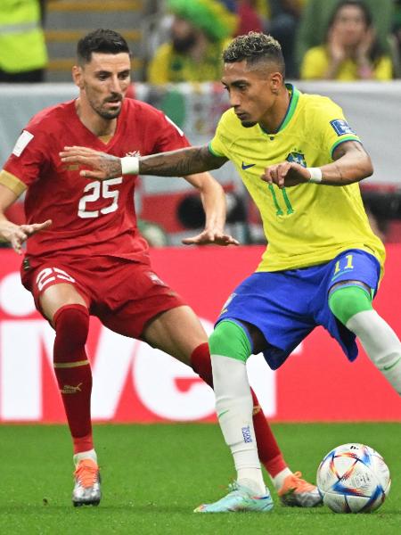 Raphinha disputa bola com Filip Mladenovic em Brasil x Sérvia pela Copa do Mundo - NELSON ALMEIDA / AFP