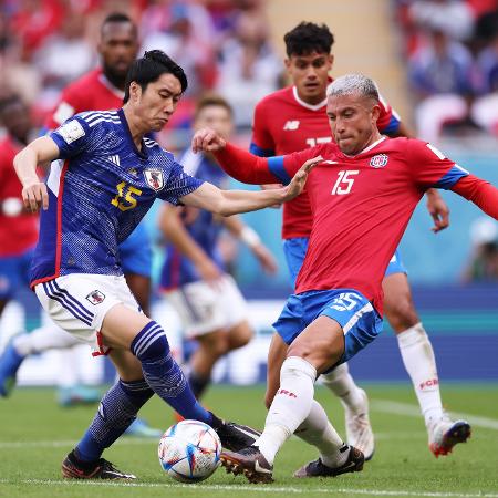 Daichi Kamada disputa a bola com Francisco Calvo na partida entre Japão e Costa Rica na Copa do Mundo - Hector Vivas - FIFA/FIFA via Getty Images