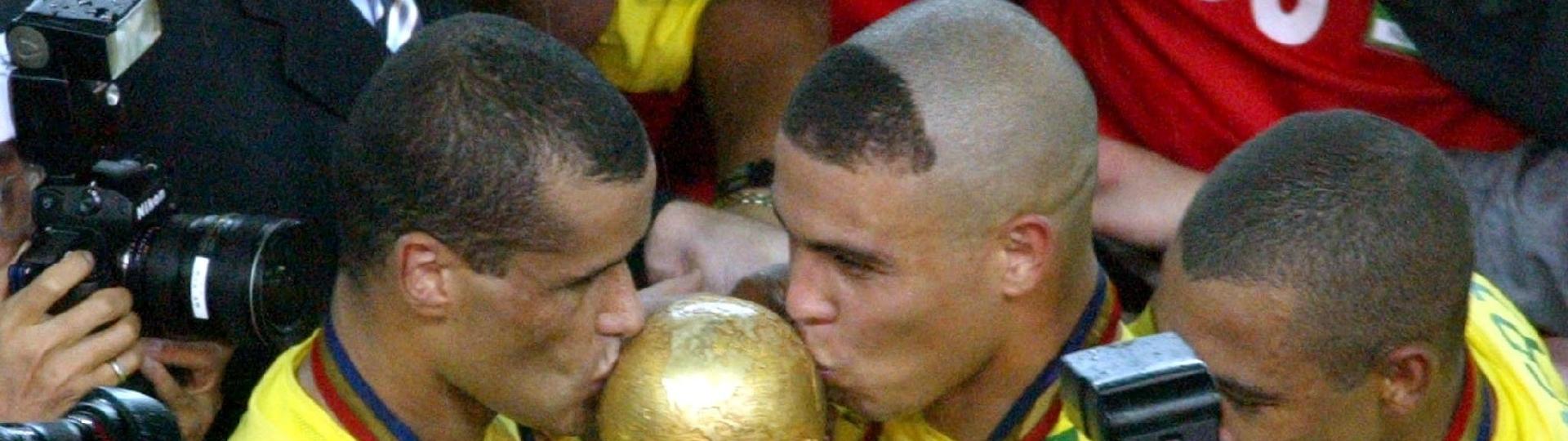 Rivaldo e Ronaldo beijam a taça da Copa do Mundo após a conquista do penta, em 2002