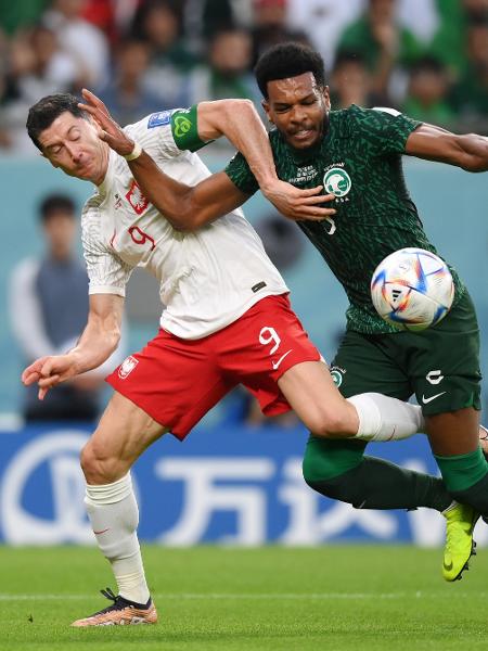 Lewandowski e Ali Al-Bulayhi disputam a bola durante a partida entre Polônia e Arábia Saudita na Copa do Mundo do Qatar - Justin Setterfield/Getty Images