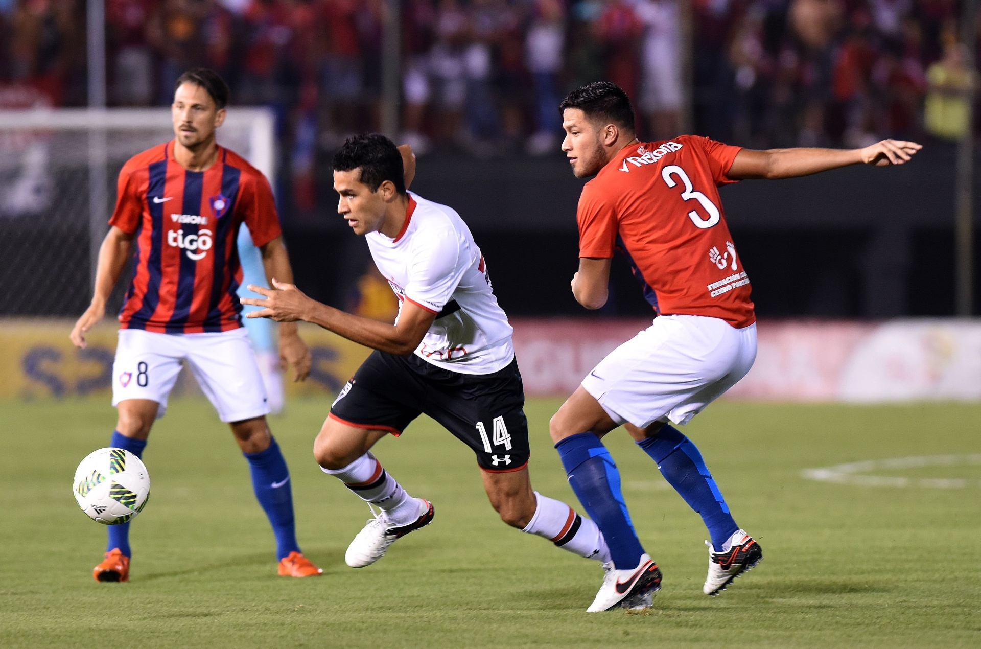 Alan Kardec duela pela bola com Jonathan Santana e Bruno Valdez no jogo do São Paulo contra o Cerro Porteño - AFP PHOTO / NORBERTO DUARTE