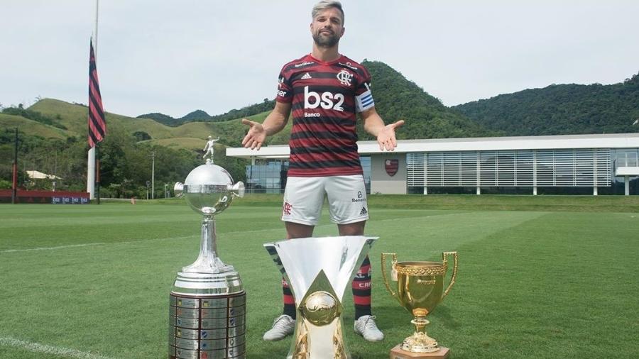 O meia Diego posa atrás das taças conquistadas pelo Flamengo em 2019: Carioca, Brasileirão e Libertadores - Reprodução/Instagram
