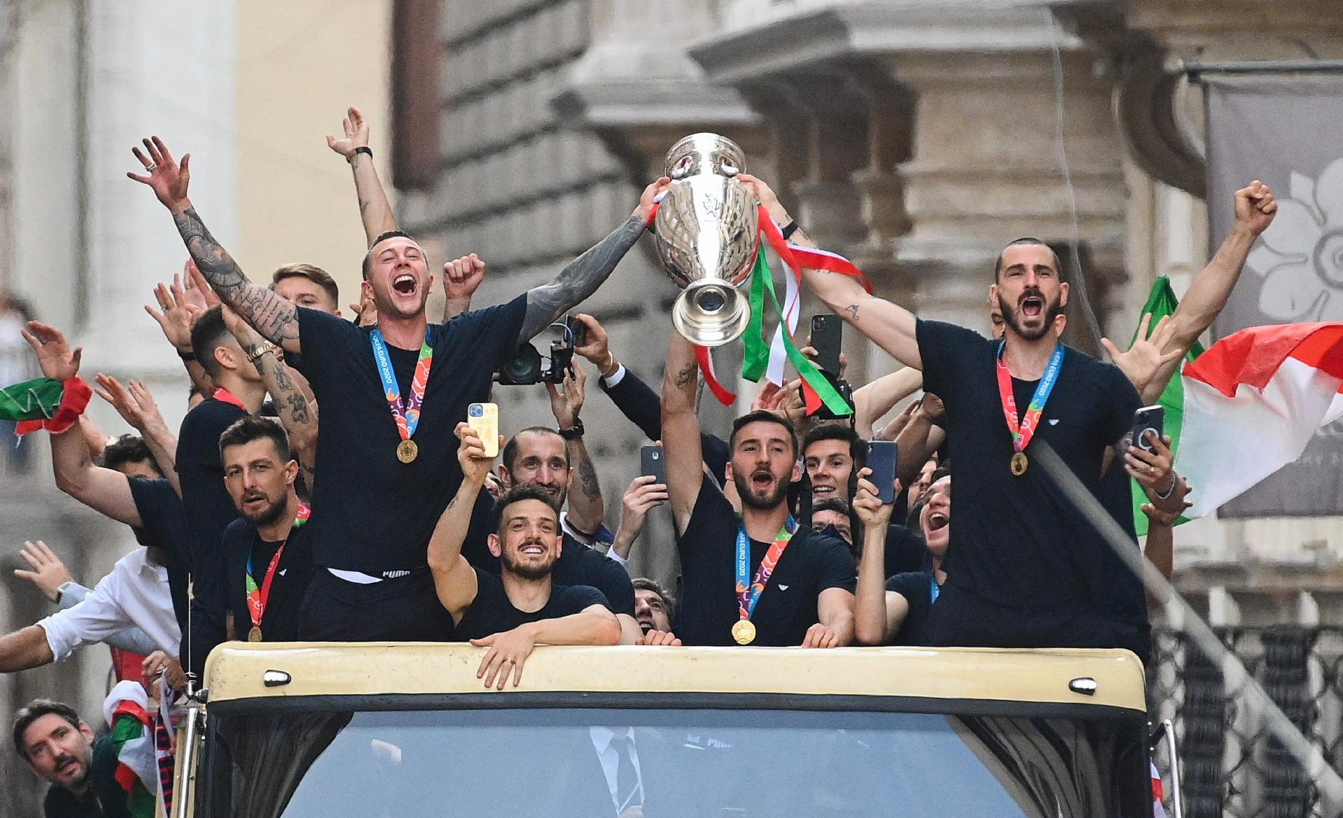 Players of Italy's national football team parade with the UEFA EURO 2020 trophy on a double decker bus in Rome on July 12, 2021, a day after Italy won the UEFA EURO 2020 final football match between Italy and England. (Photo by Vincenzo PINTO / AFP) - VINCENZO PINTO/AFP