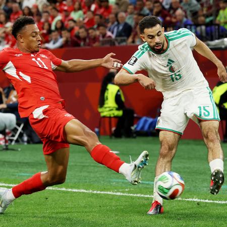 Dan Ndoye, da Suíça, disputa a bola com Rayan Ait-Nouri, da Argélia, durante jogo da Copa do Mundo