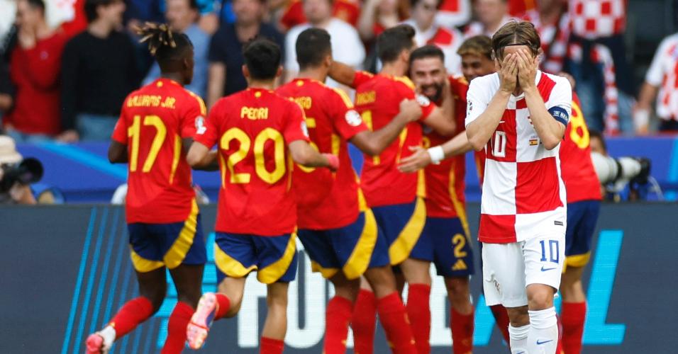 Seleção da Espanha comemora terceiro gol enquanto Modric, da Croácia, lamenta resultado