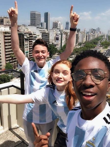 Em ordem da esquerda para a direita: Noah Schnapp (que interpreta Will Byers), Sadie Sink (Max) e Caleb McLaughlin (Lucas Sinclair) com camisas da Argentina - Reprodução