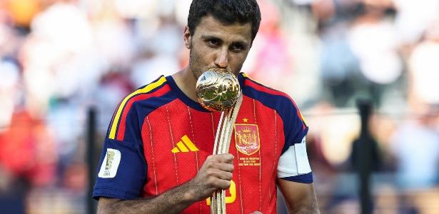 A Spanish midfielder celebrating a goal with intensity on a football pitch, dramatic lighting.