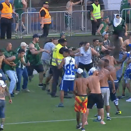 Torcedores de Coritiba e Cruzeiro se enfrentando no gramado durante jogo do Brasileirão