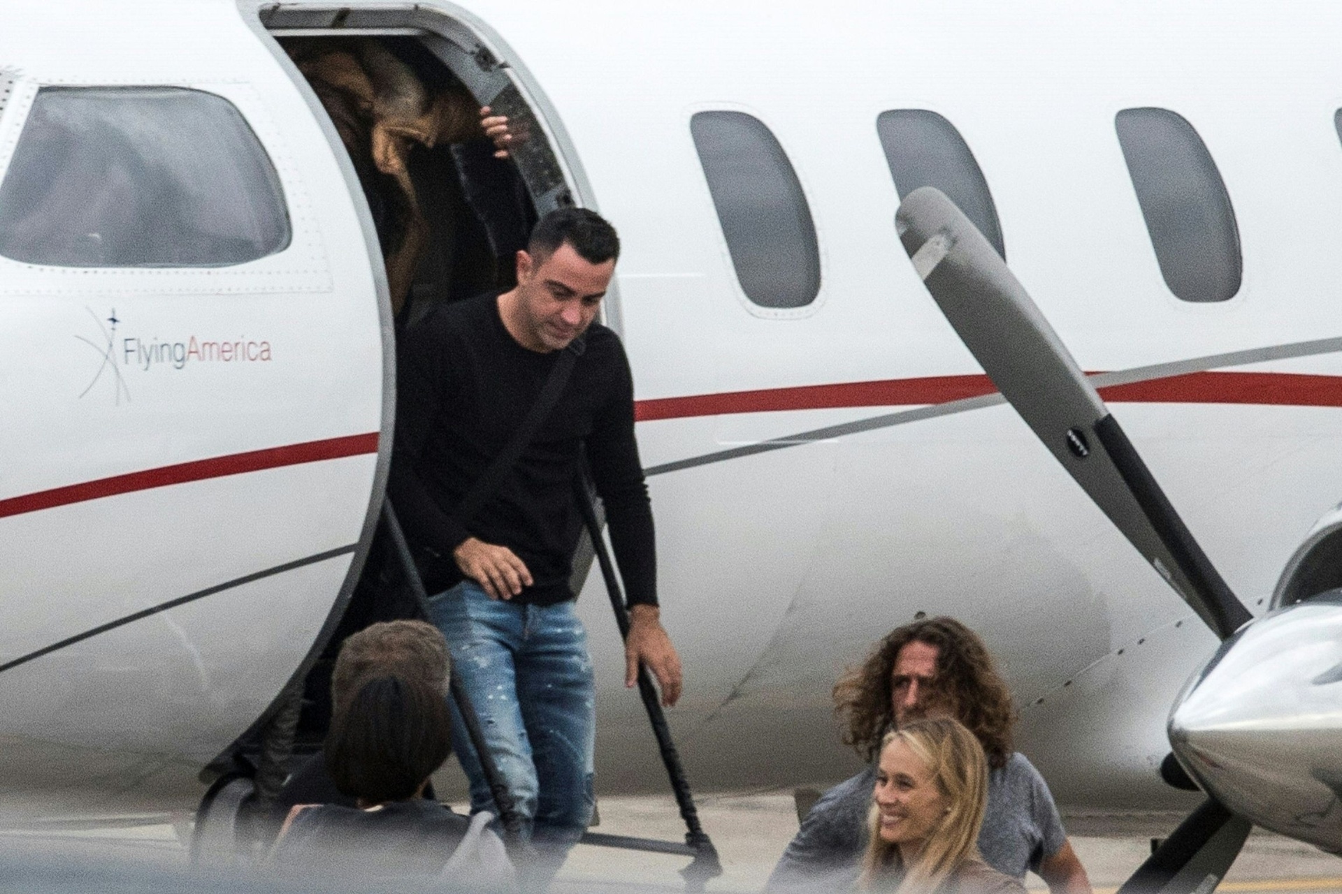 Xavi Hernandez e Carles Puyol desembarcando no aeroporto de Rosário para o casamento de Messi - Marcelo Manera/AFP Photo
