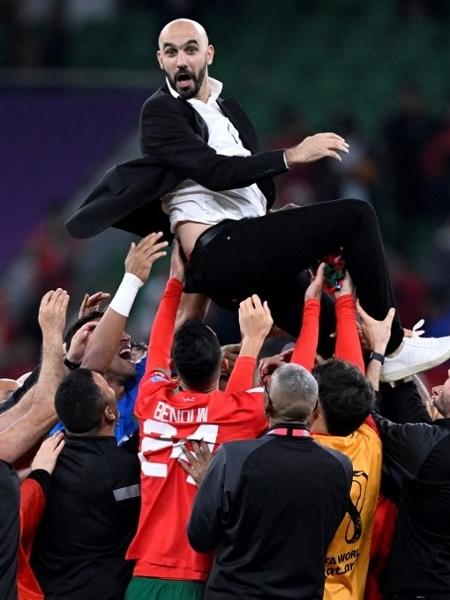 Técnico Walid Regragui é festejado pelos jogadores de Marrocos após a vitória sobre Portugal, pela Copa do Mundo do Qatar - PATRICIA DE MELO MOREIRA / AFP