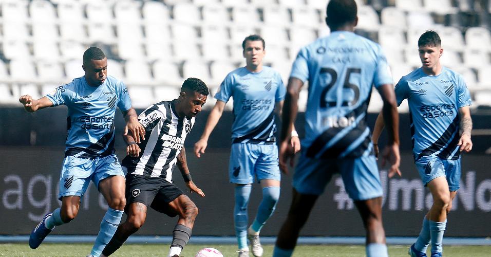 Tche Tche, do Botafogo, conduz a bola e é marcado de perto por jogadores do Athletico-PR, em jogo no Nilton Santos