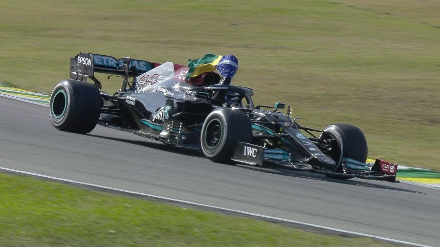 Lewis Hamilton percorre a volta de desaceleração em Interlagos carregando a bandeira do Brasil  - Fórmula 1