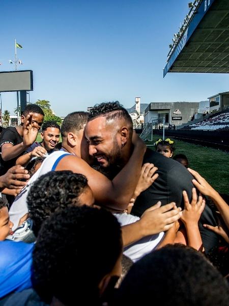 Payet é abraçado por crianças da Barreira do Vasco, comunidade vizinha ao estádio de São Januário
