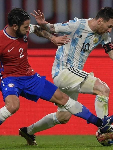 Lionel Messi disputa a bola com Mena durante o jogo entre Argentina e Chile pelas Eliminatórias da Copa  - JUAN MABROMATA/AFP