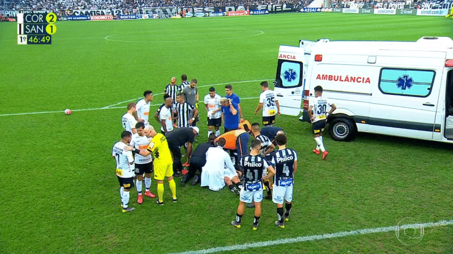 Danilo Avelar, do Corinthians, e Felipe Aguilar, do Santos, recebem atendimento no gramado - reprodução/TV Globo