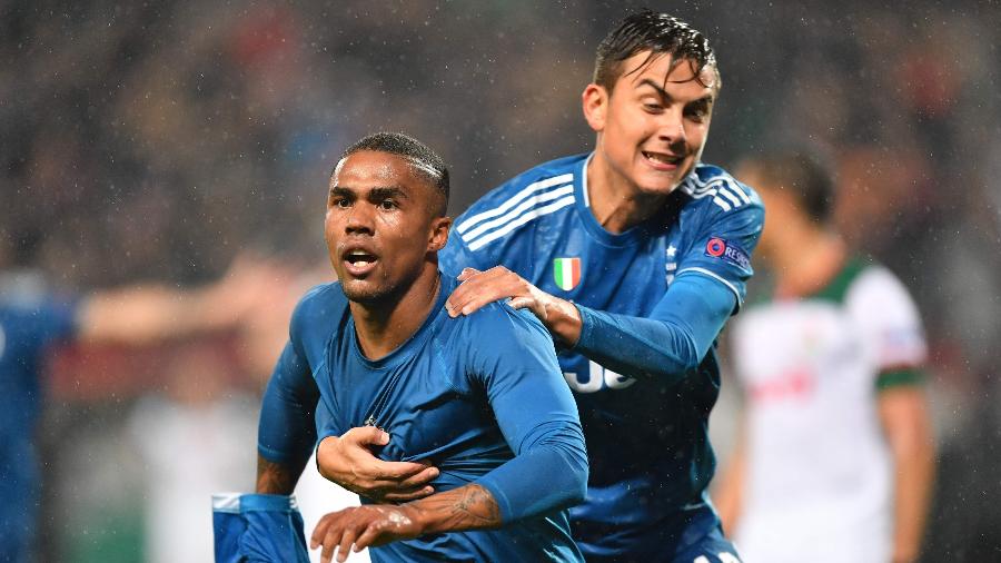 Douglas Costa (à esq.) comemora com Paulo Dybala após marcar pela Juventus - Dimitar DILKOFF / AFP